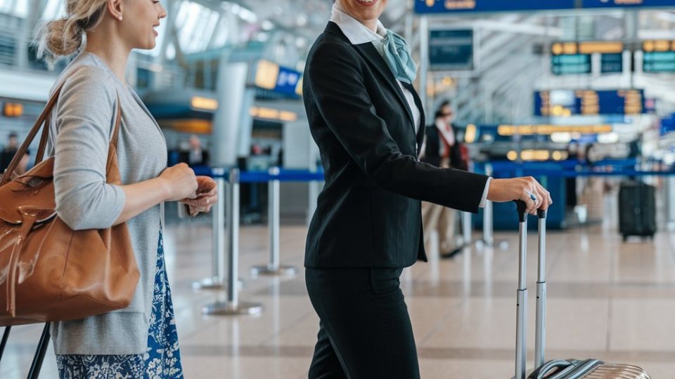 Luchthavenmedewerker helpt passagier met bagage.